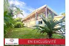 Maison vue imprenable sur océan dans grand jardin arboré,